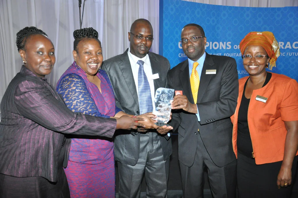 Chief Justice Dr. Willy Mutunga ( second right) who is the immediate former Ford Foundation East Africa Representative presents the Champion of Democracy Award plaque given to the KHRC to Mr. Davis Malombe, Deputy Executive Director(centre)and Ms. Atsango Chesoni, KHRC Executive Director, (second left). Also present to receive the award on behalf of KHRC are Ms. Betty Murungi, (right), vice-Chair of KHRC’s Board of Directors and Ms. Judy Ngugi (left), KHRC Finance Director.