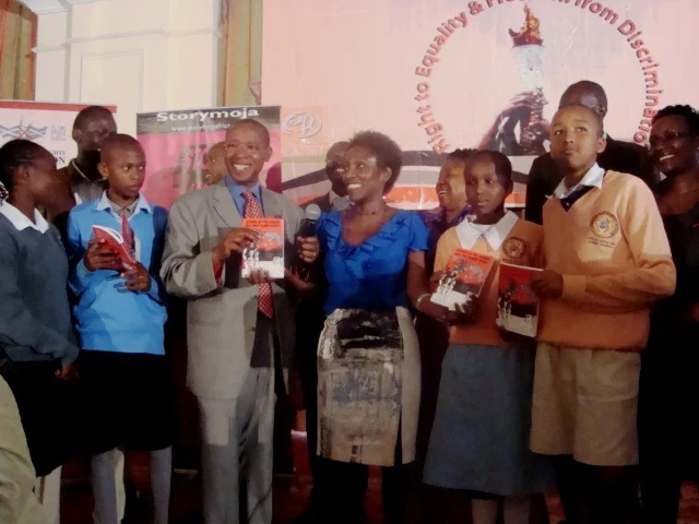 Minister for Education, Hon. Mutula Kilonzo (centre) and author, Muthoni Muchemi flanked by students from Brother Beausang Catholic Educational Centre and Catholic Parochial Primary Schools in Nairobi at the launch on Monday September 10, 2012 in Nairobi. In the back row is Ms. Atasango Chesoni, Executive Director, KHRC